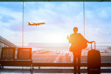 A female traveller at the airport looks out of a window © Song_about_summer/Shutterstock